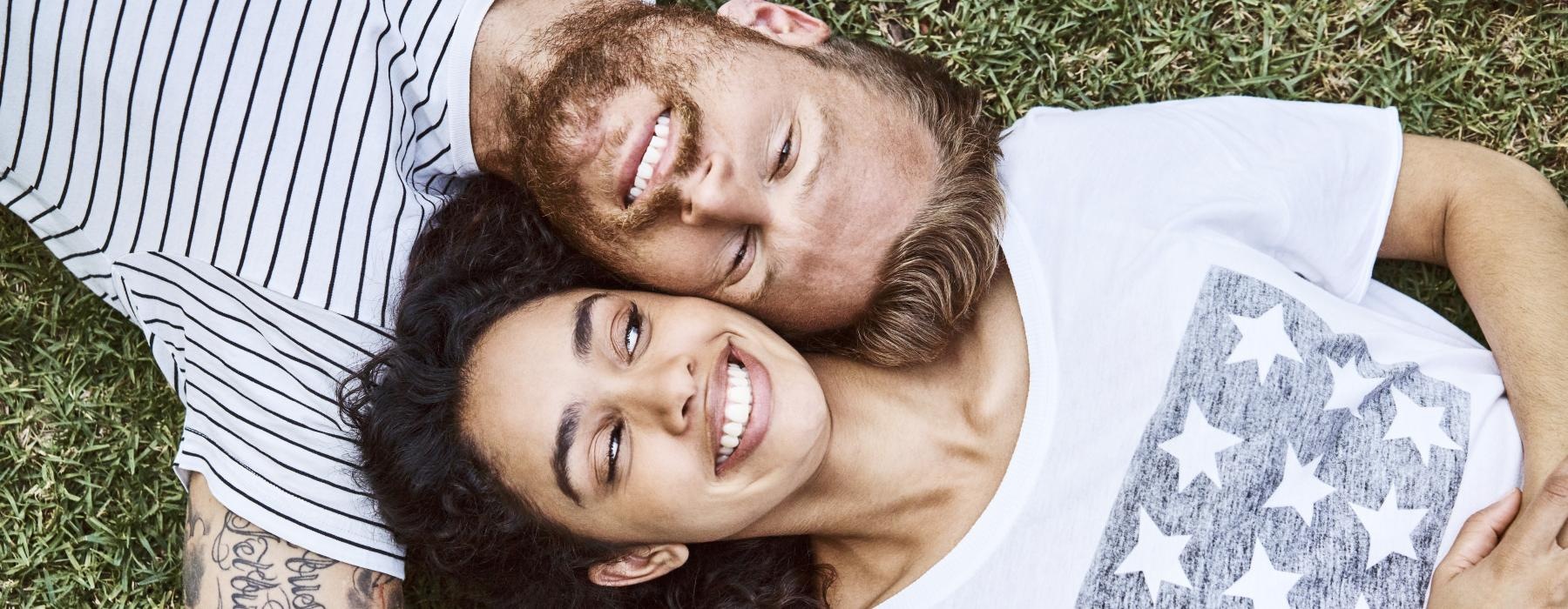 a man and woman lying in the grass